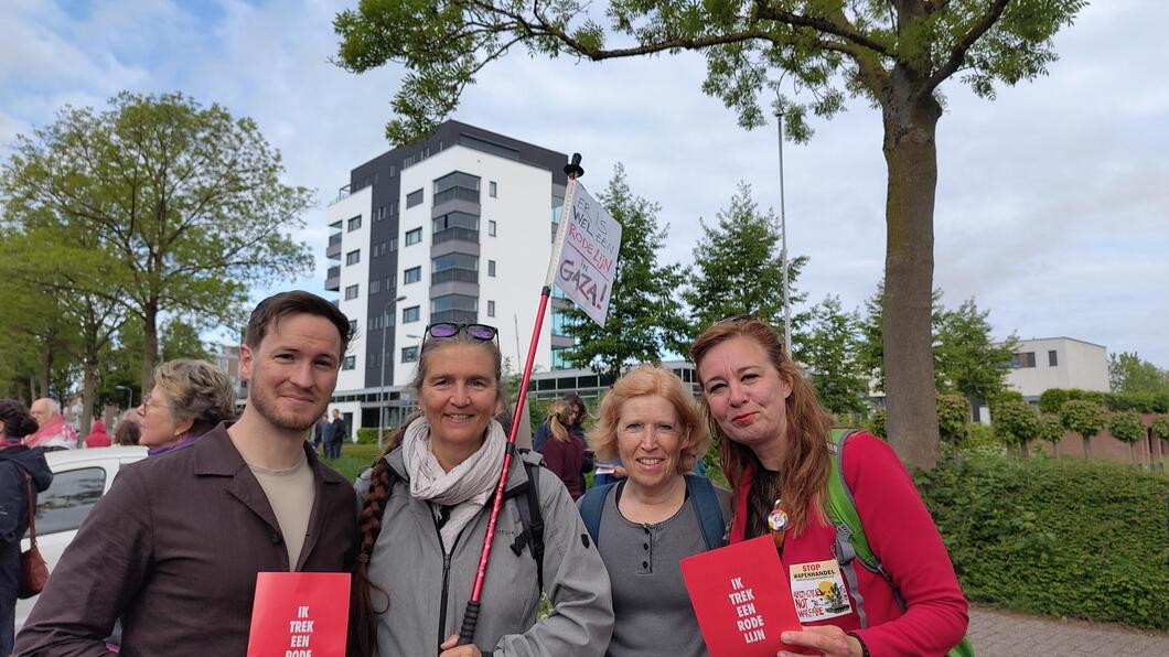 4 fractieleden GroenLinks Ede naast elkaar met een rode flyer ‘ik trek een rode lijn’ in handen en protestbord ‘er is wel een rode lijn in Gaza’.