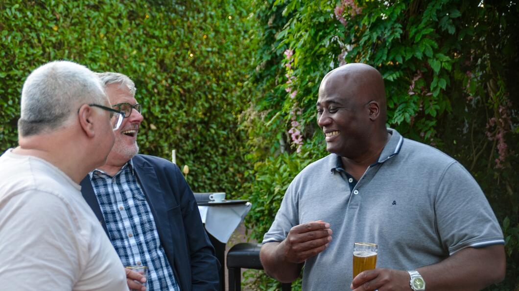 Drie personen in gesprek op zomerborrel