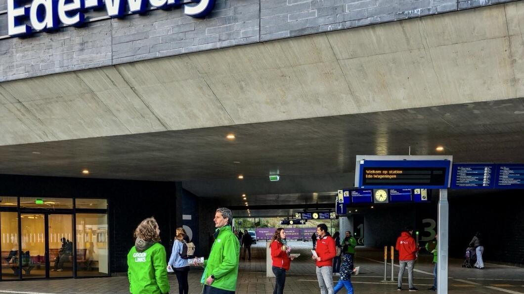 Je ziet de woorden ‘Ede-Wageningen’ eronder zie je mensen in rode en groene jasjes die lopen op het Polar Bears plein