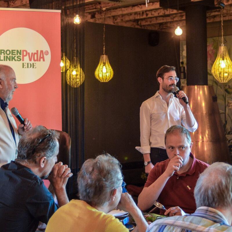 Twee mannen (te weten Evert-Jan Moraal en John van Harten) staan voor groep leden van GroenLinks en PvdA Ede.