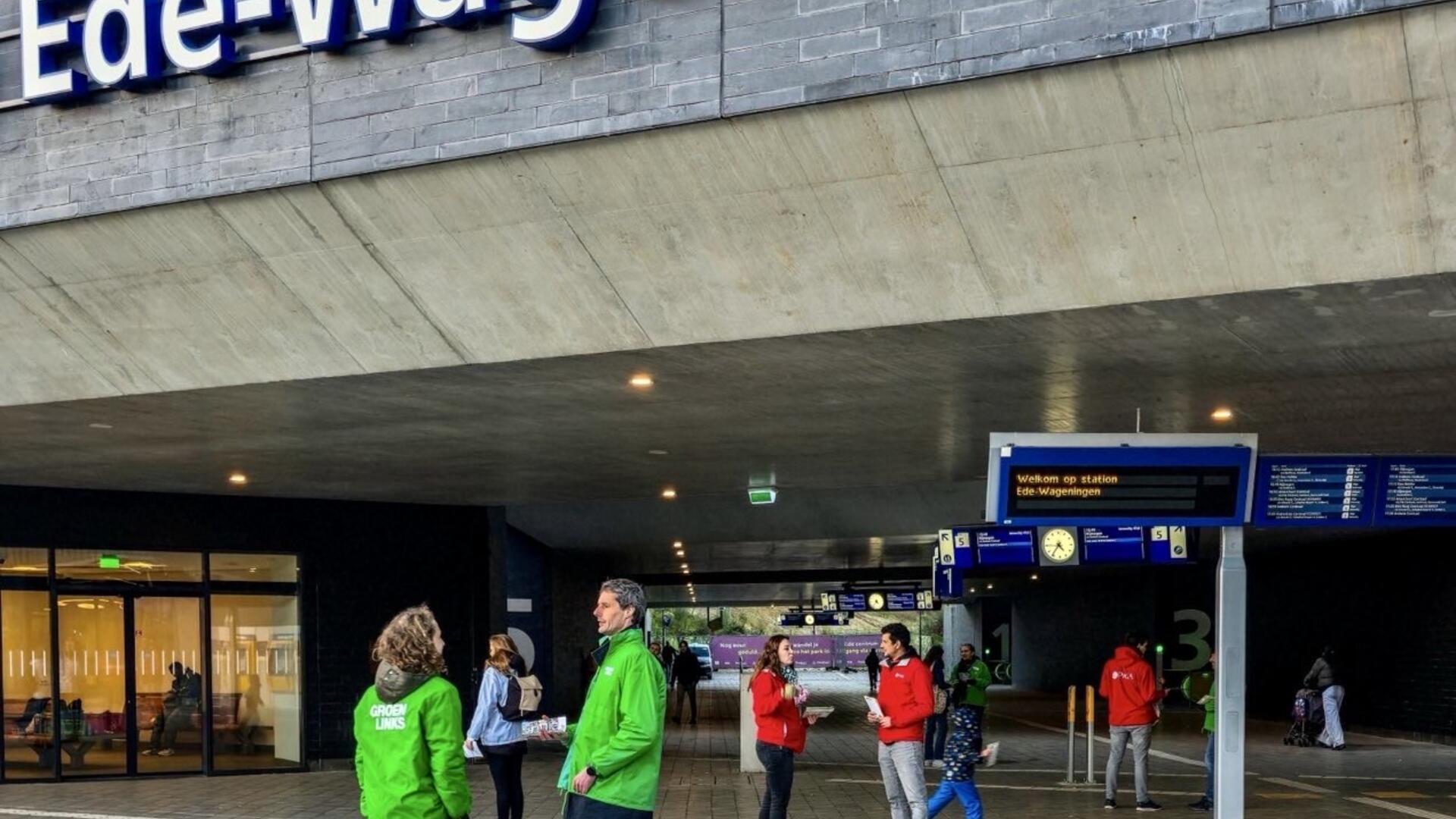 Je ziet de woorden ‘Ede-Wageningen’ eronder zie je mensen in rode en groene jasjes die lopen op het Polar Bears plein